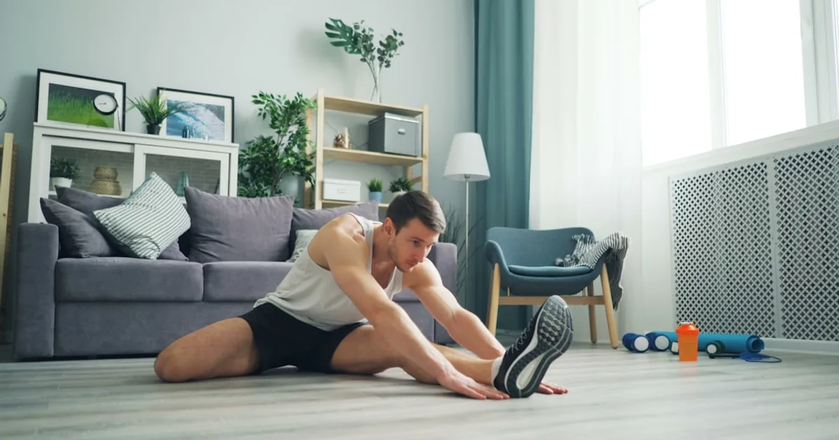 Deportista realizando estiramientos de recuperación después de un entrenamiento intenso