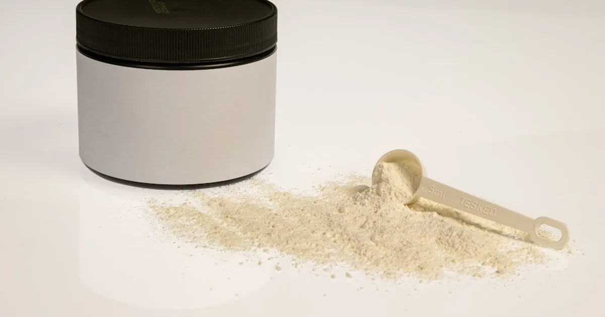 Bote de BCAAs junto a pesas en el gimnasio